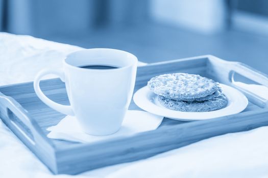 Tray with coffee and crackers breakfast on bed