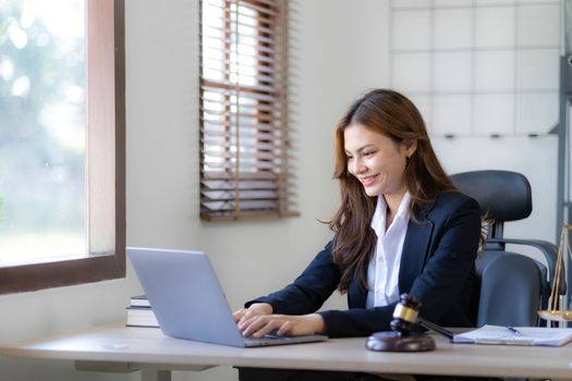 Beautiful asian woman lawyer working and gavel, tablet, laptop in front, Advice justice and law concept