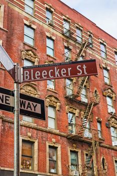 Image of Bleecker Street sign in Greenwich Village New York City with brick building behind