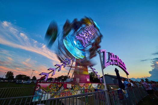 Image of Zipper carnival county fair ride blurred at dusk