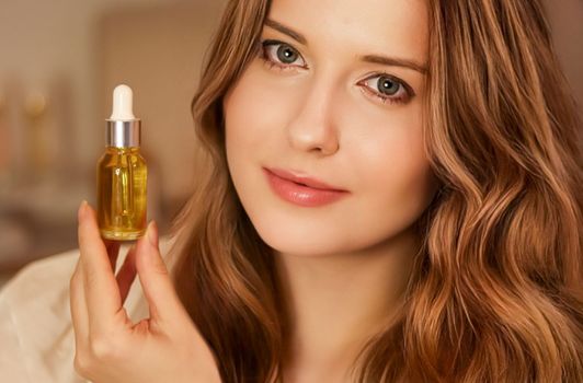 Beautiful woman with organic oil serum bottle, evening beauty and skincare routine.