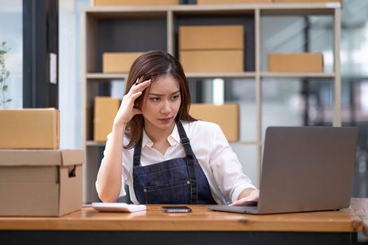 Young Asian business entrepreneur stress in online business, failure woman with working problem. SME entrepreneur and Online selling concept...
