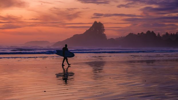 Tofino Vancouver Island Pacific rim coast, surfers with surfboard during sunset at the beach, surfers silhouette Canada Vancouver Island Tofino Vancouver Island