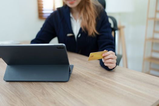 Online Shopping and Internet Payments, Beautiful Asian women are using their credit cards and tablet computer laptop to shop online or conduct errands in the digital world.