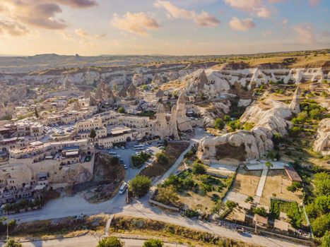 Colorful hot air balloons flying over at fairy chimneys valley in Nevsehir, Goreme, Cappadocia Turkey. Spectacular panoramic drone view of the underground city and ballooning tourism. High quality.