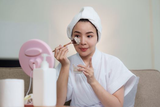 Woman with facial mask at home. Skin care, face treatment, spa, cosmetology and natural beauty concept.