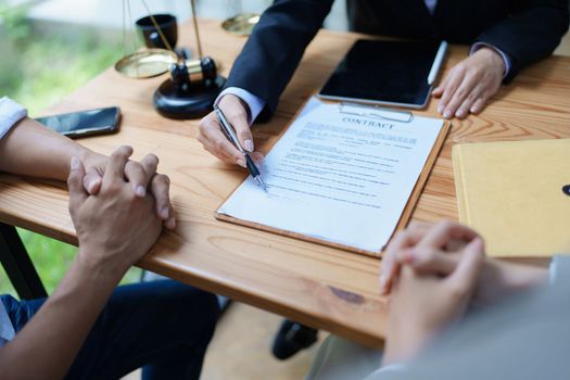 Lawyer hands important documents to couple to sign.