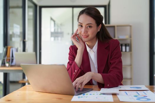 Female employee using laptop at workplace. Businesswoman preparing economic report by laptop computer.