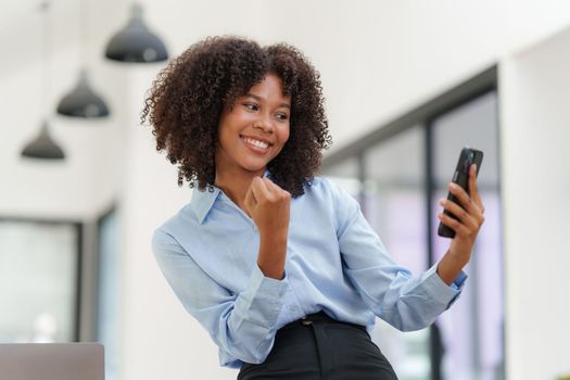 Business black woman having phone conversation with client in office. Woman reading news, report or email. Online problem, finance mistake, troubleshooting.