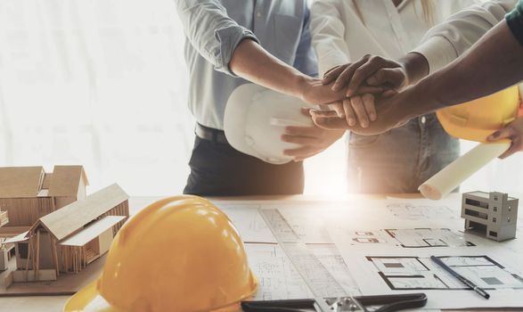 Businessmen and engineers join hands to build successful projects. Teamwork concept...