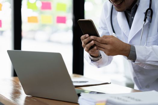 Doctor working using cell phone at clinic. Medical technology and network concept.