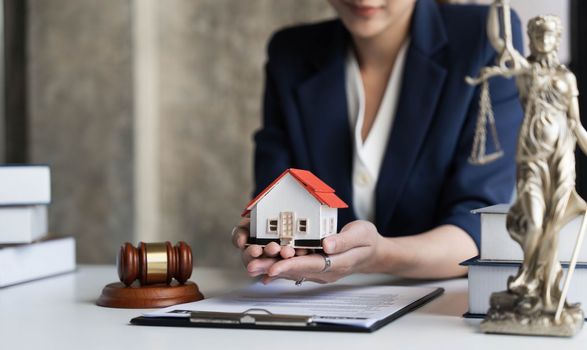 Real estate concept, businesswoman holding a house icon. House on Hand.Property insurance and security concept. Protecting gesture of female and symbol of house