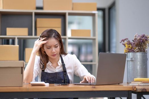 Young Asian business entrepreneur stress in online business, failure woman with working problem. SME entrepreneur and Online selling concept...