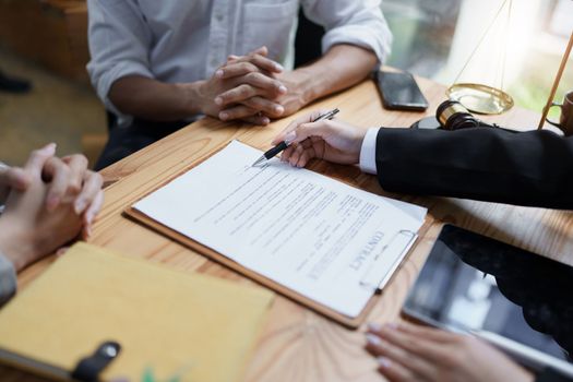 Lawyer hands important documents to couple to sign.