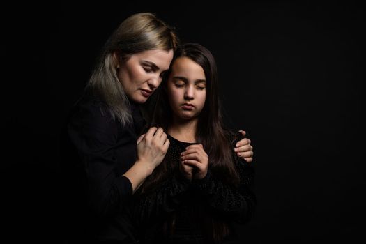 mother and her little girl praying.