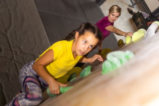 mother and daughter climb on the climbing wall. Family sport, healthy lifestyle, happy family.