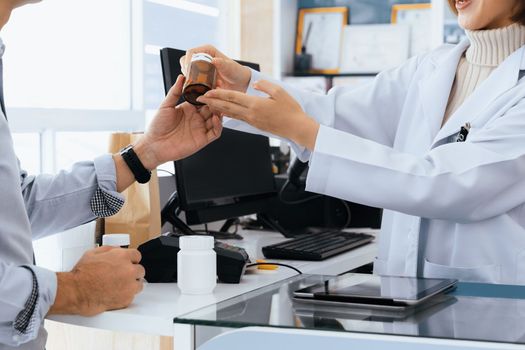 Closeup professional pharmacist advise or explain property of qualified medical product to customer in pharmacy, druggist answer to client healthcare inquiry, medical service and consultation concept.