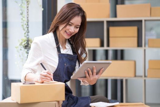 Successful entrepreneur business woman with online sales and Parcel shipping in her home office, prepare parcel box of product for deliver to customer...