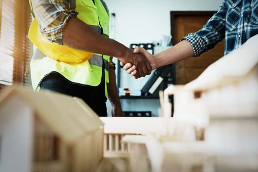 Engineers shaking hands to congratulate after success To create a building architecture successfully according to the goals that have been set.