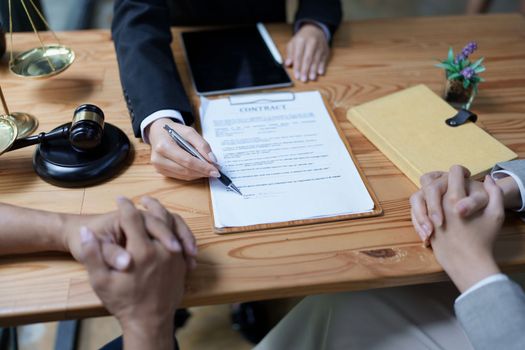 Lawyer hands important documents to couple to sign.