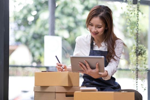 Successful entrepreneur business woman with online sales and Parcel shipping in her home office, prepare parcel box of product for deliver to customer...