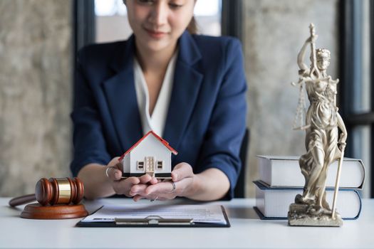 Real estate concept, businesswoman holding a house icon. House on Hand.Property insurance and security concept. Protecting gesture of female and symbol of house