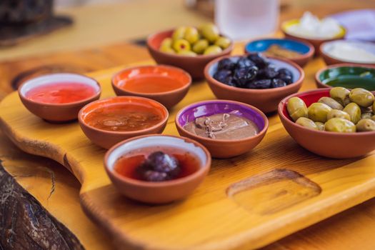 Turkish breakfast table. Pastries. Vegetables. Olives. Cheeses, fried eggs. Jams, tea in copper pot and tulip glasses. Wide composition.