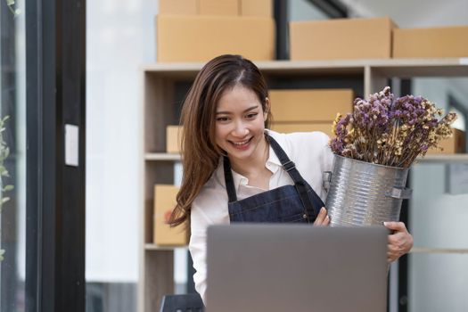A portrait of a small startup, an SME owner, an Asian female entrepreneur checking orders to arrange the produce before packing the products in the inner boxes with the customers. Freelance concepts..