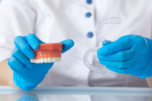 Orthodontist showing how the system of transparent aligners works on an artificial jaws
