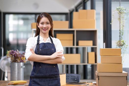 Portrait of young Asian woman working SME with a box at home the workplace.start-up small business owner, small business entrepreneur SME or freelance business online and delivery concept...