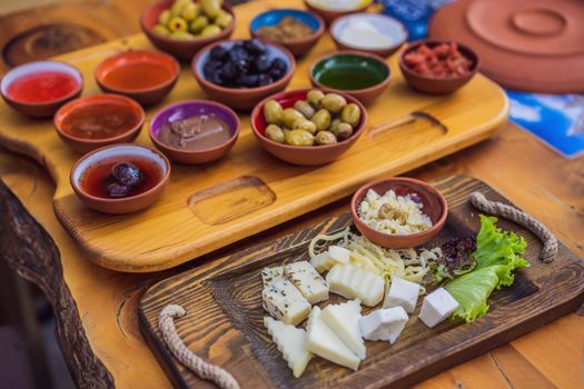 Turkish breakfast table. Pastries. Vegetables. Olives. Cheeses, fried eggs. Jams, tea in copper pot and tulip glasses. Wide composition.