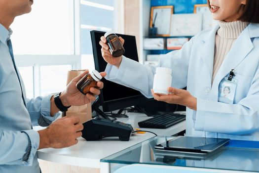 Closeup professional pharmacist advise or explain property of qualified medical product to customer in pharmacy, druggist answer to client healthcare inquiry, medical service and consultation concept.