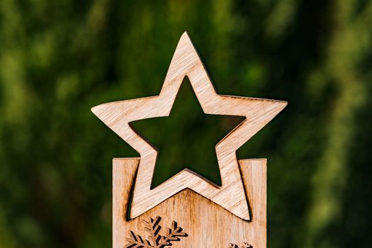 Star decoration element made of wood for Christmas in front of a naturally green background
