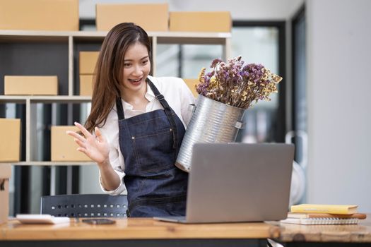 A portrait of a small startup, an SME owner, an Asian female entrepreneur checking orders to arrange the produce before packing the products in the inner boxes with the customers. Freelance concepts..