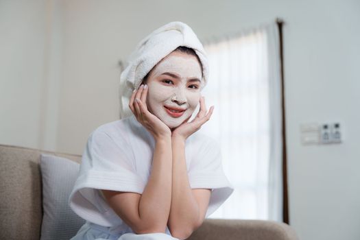 Woman with facial mask at home. Skin care, face treatment, spa, cosmetology and natural beauty concept.