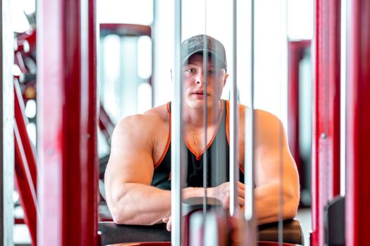 athlete resting in the gym between exercises with machines.