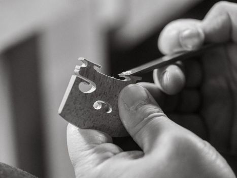 artisan shaving a bridge for precision instrument placement