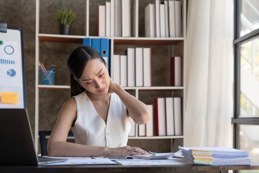 Young Business Asian women are stressed while working on laptop, Tired asian businesswoman with headache at office, feeling sick at work copy space in workplace an home office...