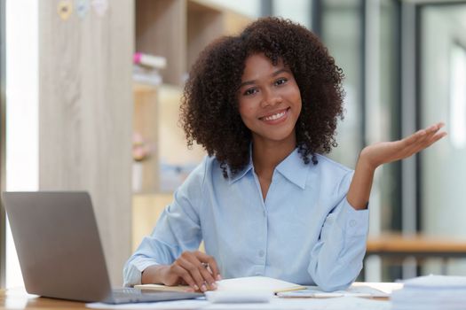 Young African American businesswoman working by laptop at office, Focus at screen laptop, reading interesting article online and finance.