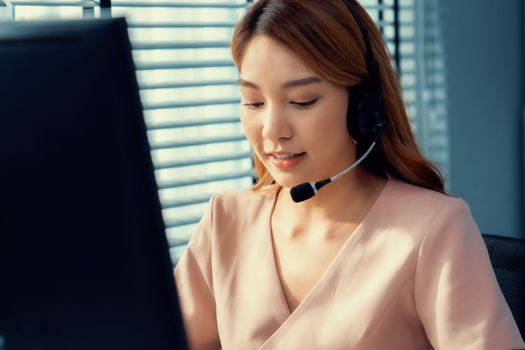 Competent female operator working on computer and while talking with clients. Concept relevant to both call centers and customer service offices.