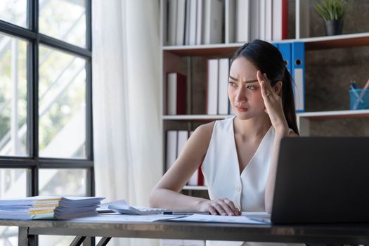Young Business Asian women are stressed while working on laptop, Tired asian businesswoman with headache at office, feeling sick at work copy space in workplace an home office...