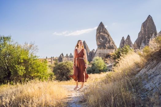 Woman tourist on background of Unique geological formations in Love Valley in Cappadocia, popular travel destination in Turkey.