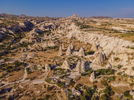 Colorful hot air balloons flying over at fairy chimneys valley in Nevsehir, Goreme, Cappadocia Turkey. Spectacular panoramic drone view of the underground city and ballooning tourism. High quality.