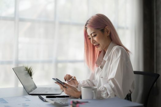 Asian Business woman working to analyze technical price graph and indicator with business team talking by cell phone. account or saving money or insurance concept.