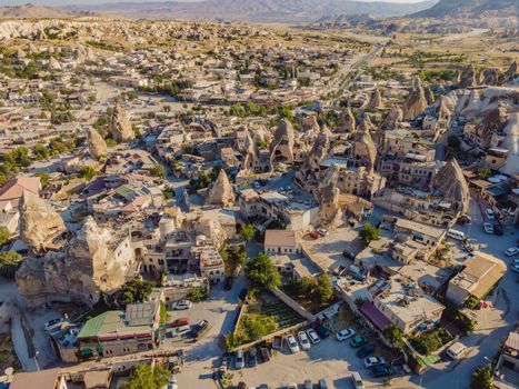 Colorful hot air balloons flying over at fairy chimneys valley in Nevsehir, Goreme, Cappadocia Turkey. Spectacular panoramic drone view of the underground city and ballooning tourism. High quality.