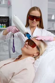 Woman receiving laser treatment in clinic, beauty concept