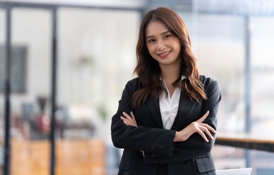 Charming Young Asian businesswoman standing in the office. Looking at camera...