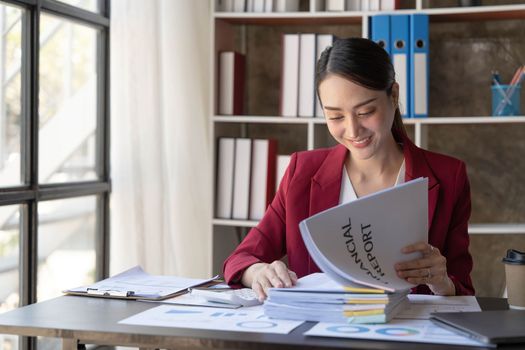 Beautiful young Asian girl working at a office space with a laptop. Concept of smart female business