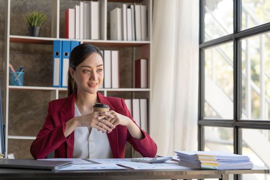 Beautiful young Asian girl working at a office space with a laptop. Concept of smart female business