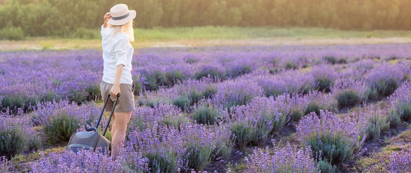 woman with suitcase in lavender field